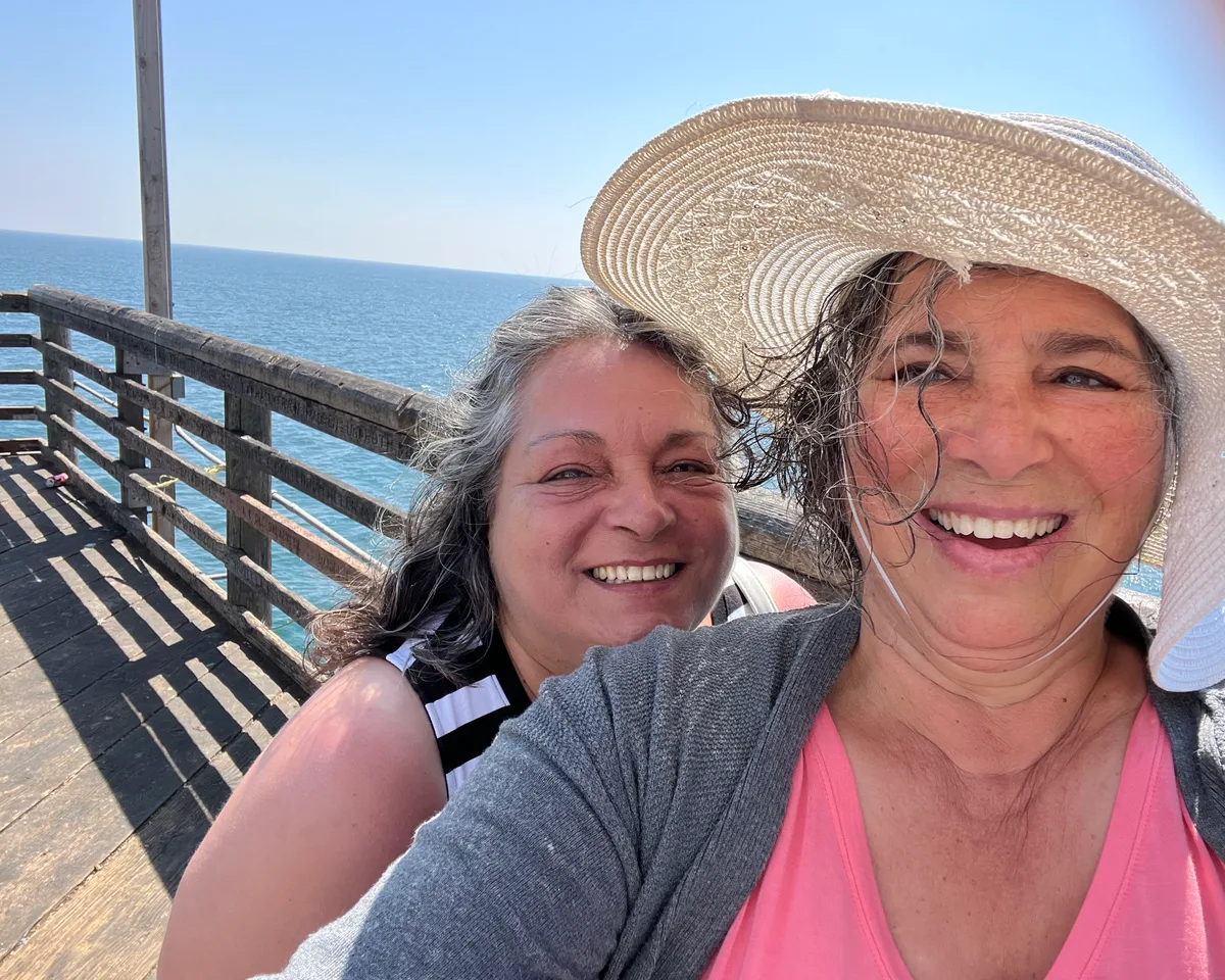 Terri Lee laughing in the sunshine on an ocean pier